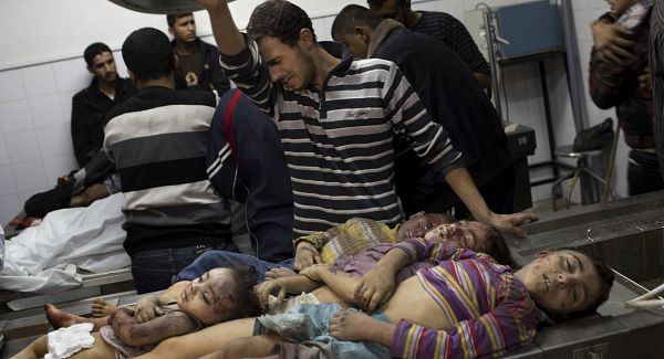 A Palestinian man cries next the dead bodies of four children in the morgue of Shifa Hospital in Gaza City, Sunday, Nov. 18, 2012. An Israeli missile flattened a two-story house in a residential neighborhood of Gaza City on Sunday, killing at least 11 civilians shortly after Israel announced plans to intensify an offensive by attacking the homes of wanted militants, medical officials said. Gaza health official Ashraf al-Kidra says five women, including an 80-year-old woman, and four small children were among the dead. (AP Photo/Bernat Armangue)